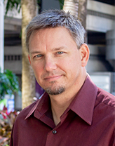 Man wearing dark red shirt in an outdoor setting