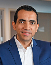 Man wearing a blue suit and white shirt in an office setting