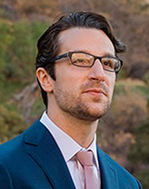 Man in a suit and glasses in an outdoor setting