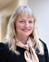 Britta Ton in a black dress and brown scarf.