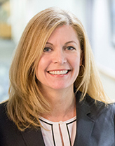 Elizabeth Bennett wearing a dark suit jacket pictured in an office setting.