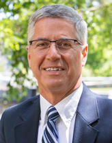 Greg Bakos in a navy suit.