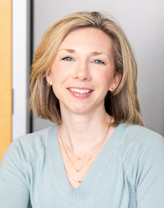 Julie Whitmore smiling in a light blue blouse.