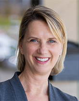 Meredith Avery smiling in a Dark gray blazer.