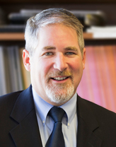 Peter Walker smiling in a dark gray suit.