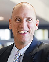 Rob Smedberg smiling, wearing a navy blazer.