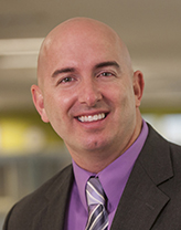 Shawn Tofte with a purple shirt and striped tie