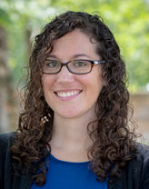 Headshot of Stephanie Wyman wearing business casual attire and smiling in an outdoor setting.