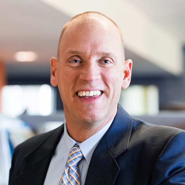 Rob Smedberg smiling, wearing a navy blazer.