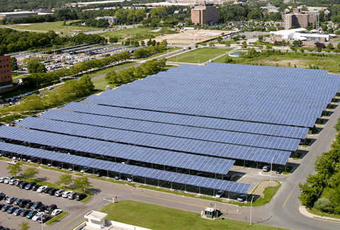 Solar panels are installed over parking spaces to maximize solar energy collection.