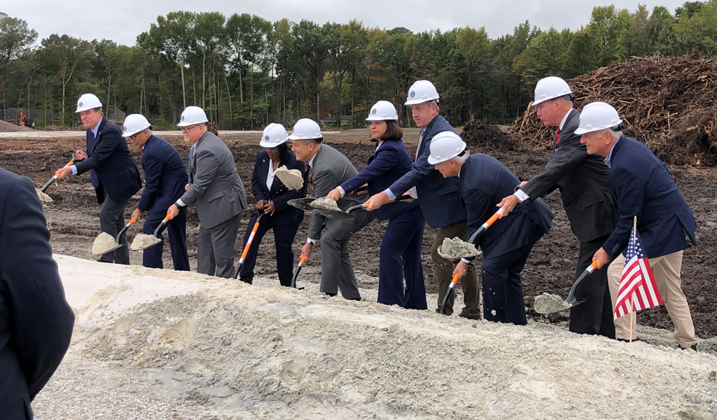 Project stakeholders hold shovels and move dirt to signify the groundbreaking of the new CBOC Hampton Roads.