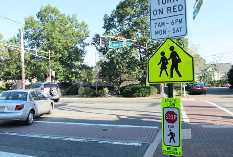 A traffic sign to promote pedestrian safety at an intersection. 
