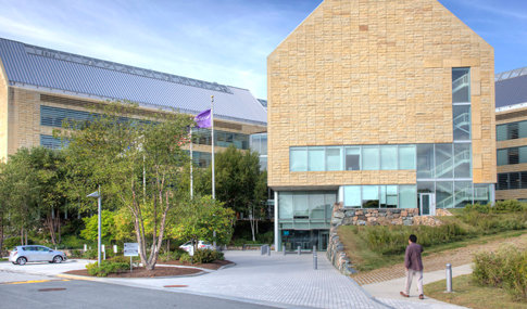 A man walks toward the main entrance of the Astra-Zeneca campus.