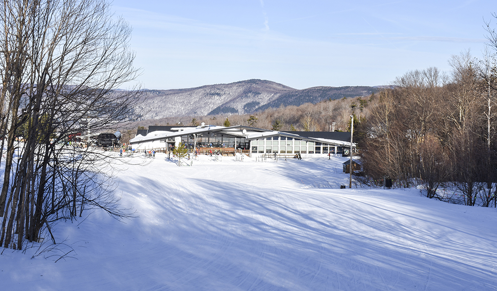 Killington old lodge surrounded by snow mountains.