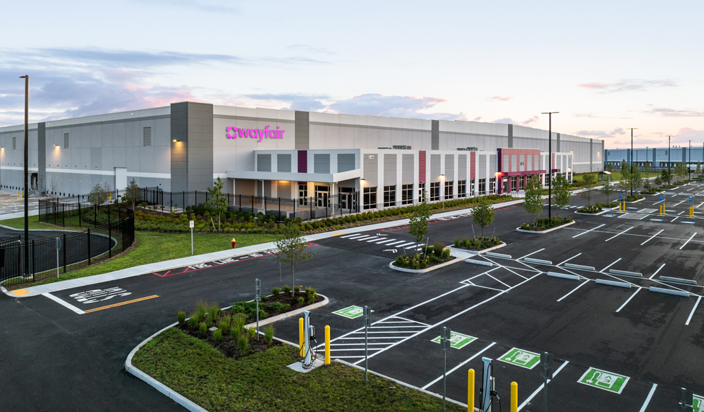 A Wayfair logistics center with parking lot featuring EV charging stations.