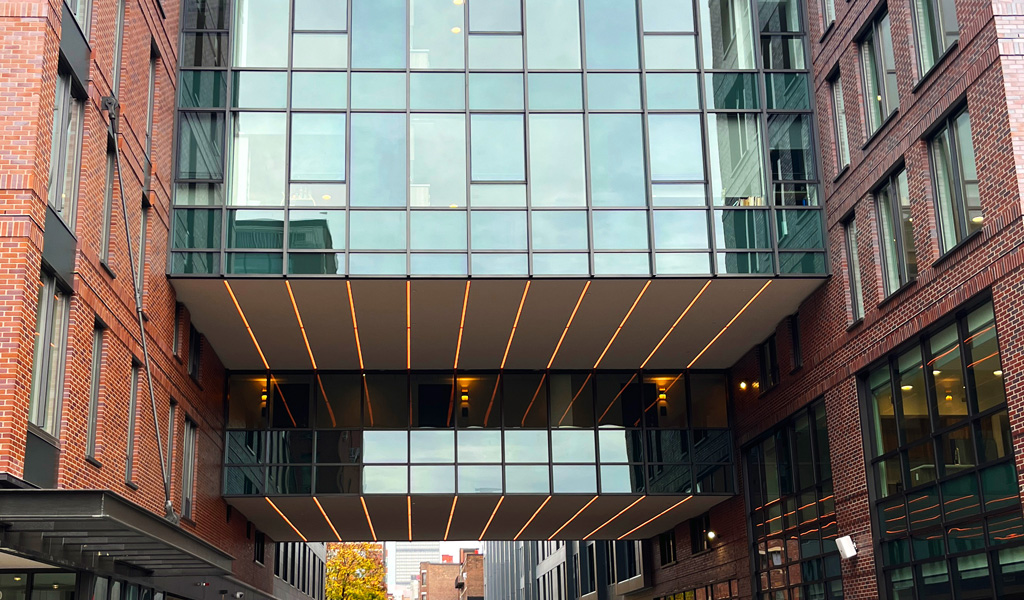 A multistory glass and brick building with glass sky bridge.