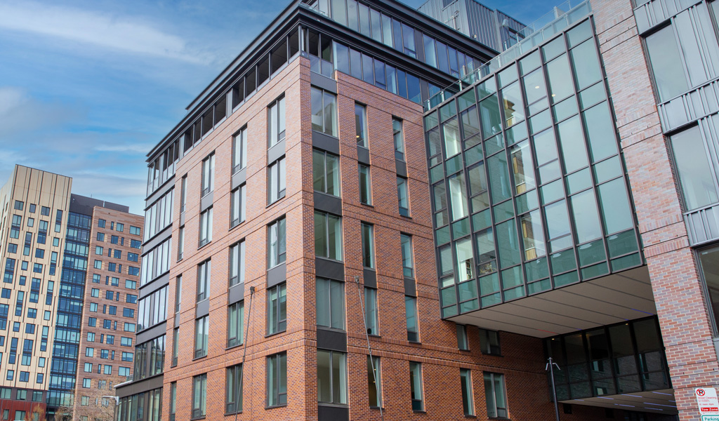 A multistory glass and brick building with glass sky bridge.