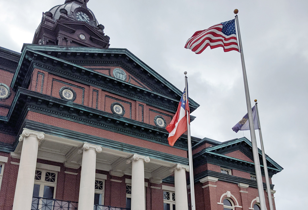 An historic brick two story building with flags in front