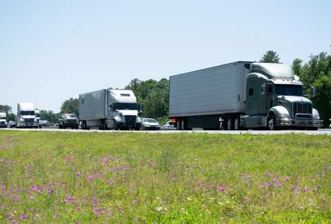 Semi-trucks traveling down an interstate.