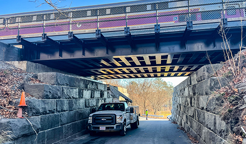  MBTA commuter rail train operates over newly constructed bridge over Intervale Road in Weston, MA.