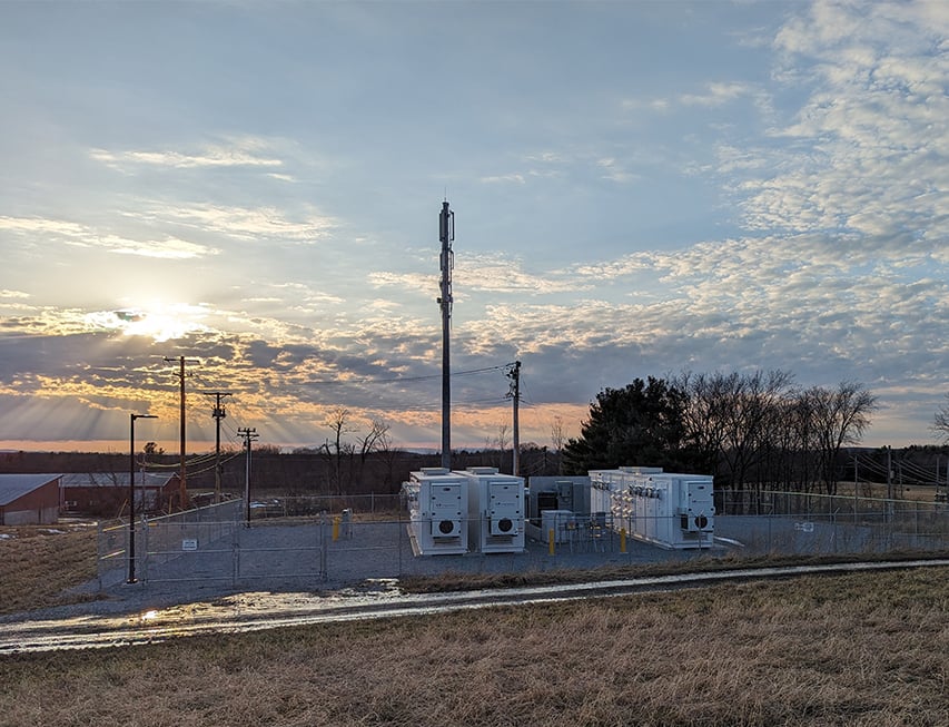 A field with electrical equipment in the background.