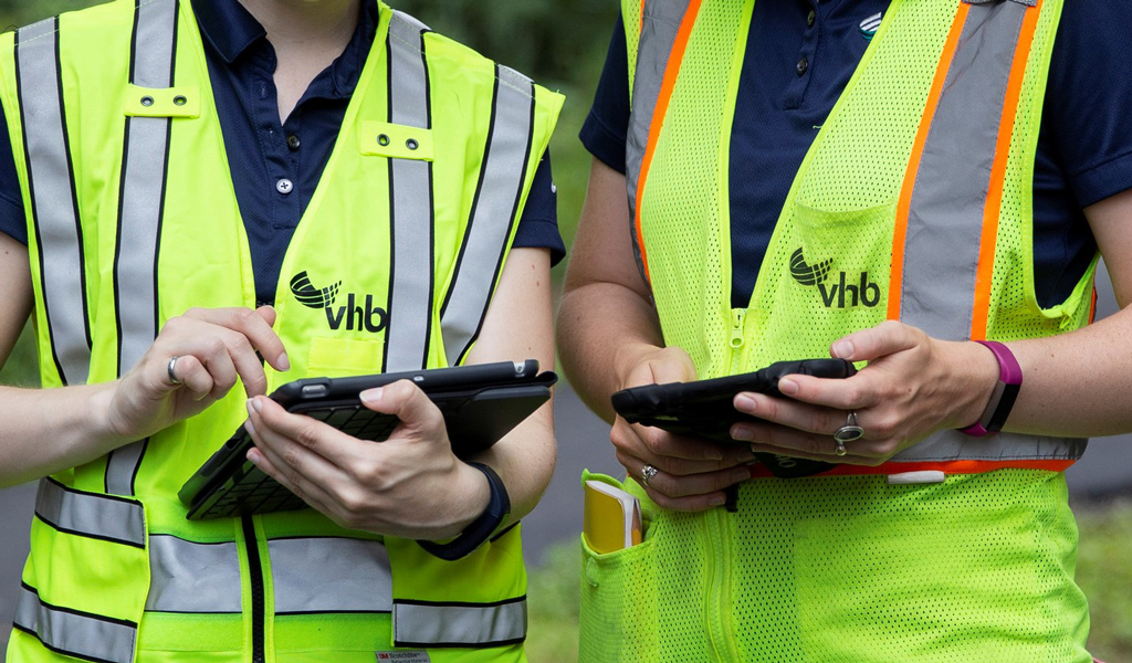 Two VHB Employees use tablets during an environmental site visit