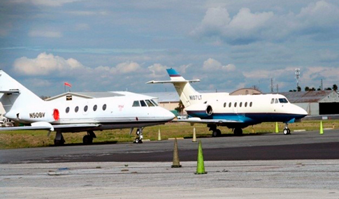 Two small airplanes sitting at the Greater Orlando Airport