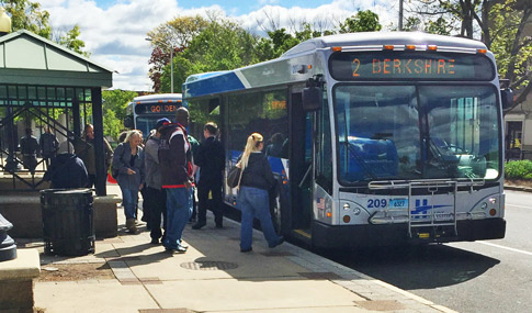 A bus at a bus stop with passengers entering.