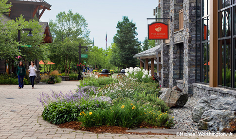 Pedestrians walk outside the Lodge at Spruce Peak .