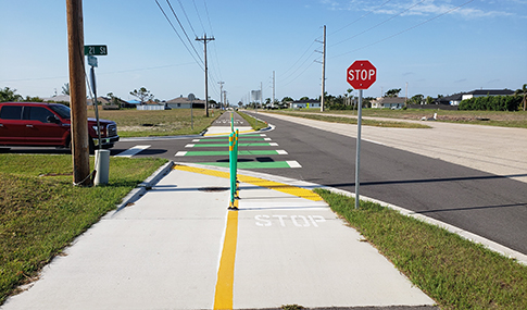 A multimodal trail with stop sign along a highway.