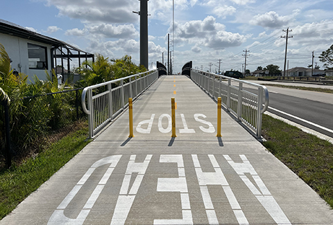 Painted letters indicating Stop Ahead on a multimodal trail path.