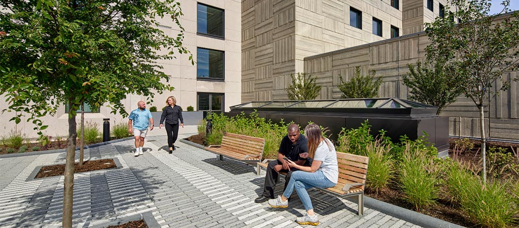 View outside of the Children’s Hospital Research Buildings with ADA accessible walkways and people seated in the foreground.