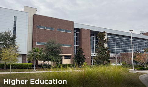 A classroom building with native grasses and trees planted in front