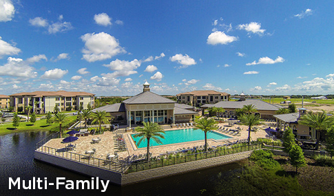 A pool and clubhouse with apartments surrounding it