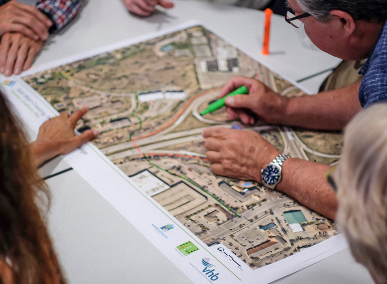 People leaning over and writing on a map on a conference table 