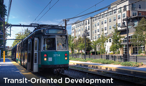 A train arrives at its station surrounded by new residential apartments.