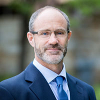 Tim Upton in a suit and tie in an outdoor setting