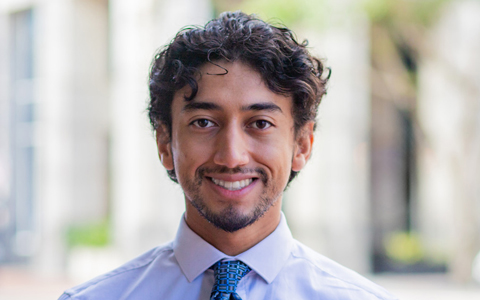 Adrian Santiago smiling in an office setting.