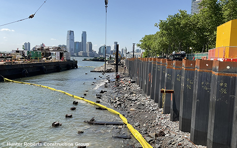 A construction site with a river and a city in the background