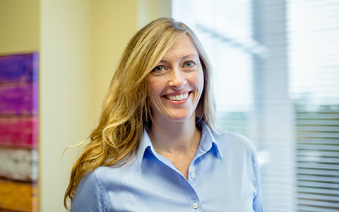 Candice Andre smiling in a blue dress shirt