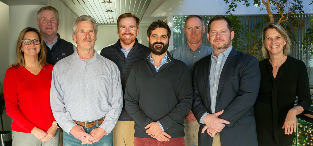 Eight people smiling at the camera.