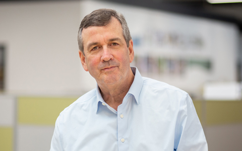 Dan Faust in the office wearing a blue button-down shirt.