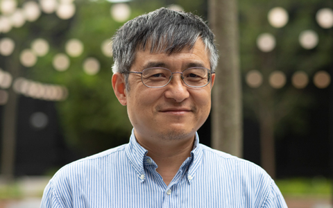 James Shao smiling outside in blue button down