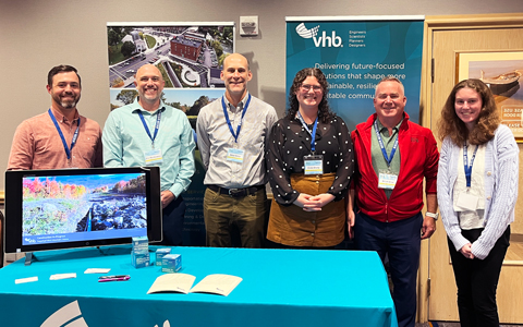 VHB Team members Garrison Beck, Eric Monkiewicz, Peter Smiar, Zelda Dively, Adam Bliss, and Caroline Herzog stand at the VHB table.