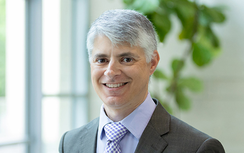 Paul Vitalino smiling in a jacket and tie.