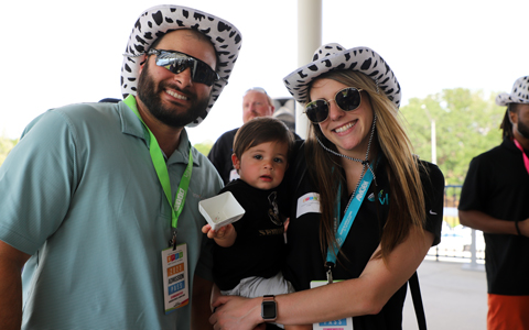 A man, woman, and child wearing funny hats and smiling