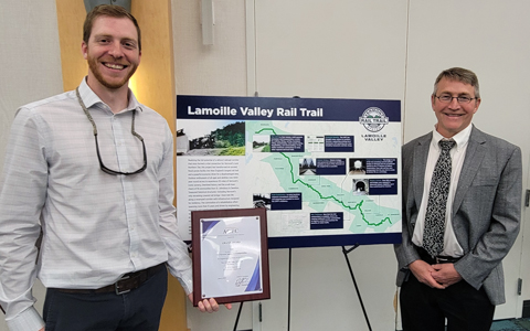 VHB team members smiling in front of project poster.