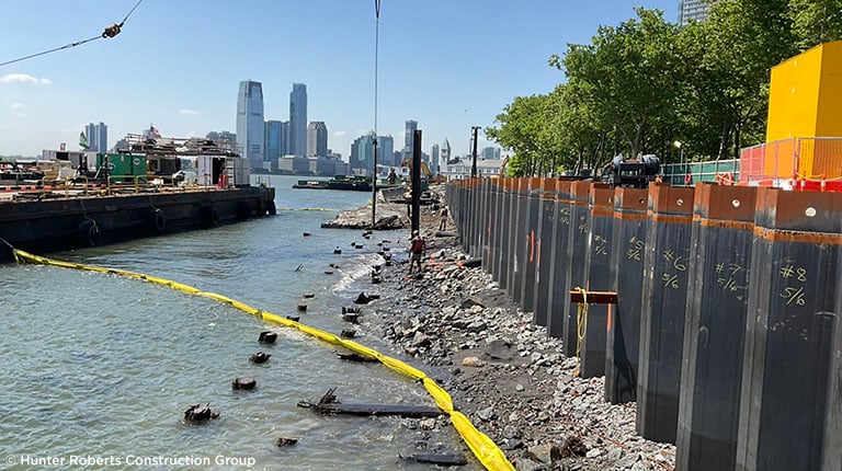 A construction site with a river and a city in the background