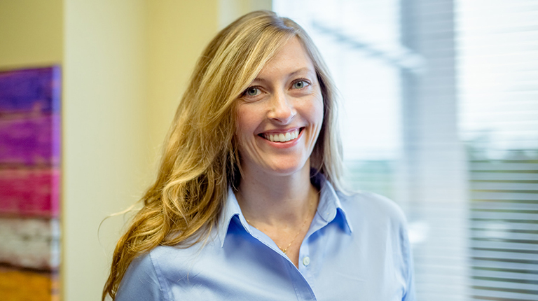 Candice Andre smiling in a blue dress shirt