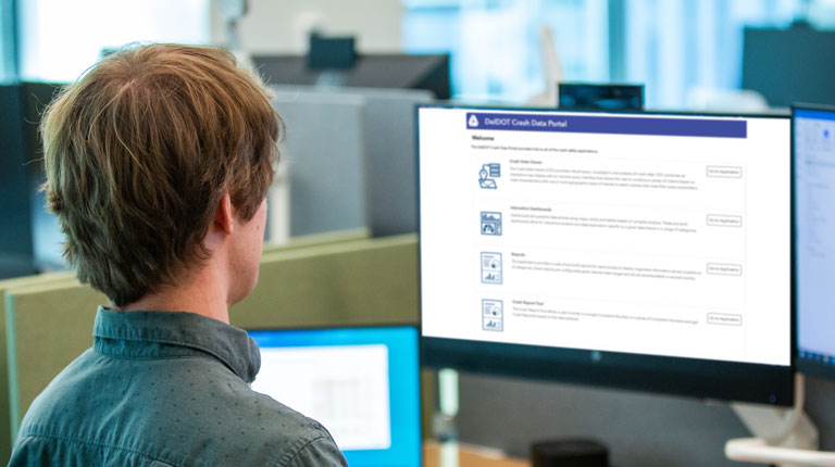 A man looks at a safety dashboard on a monitor at work.